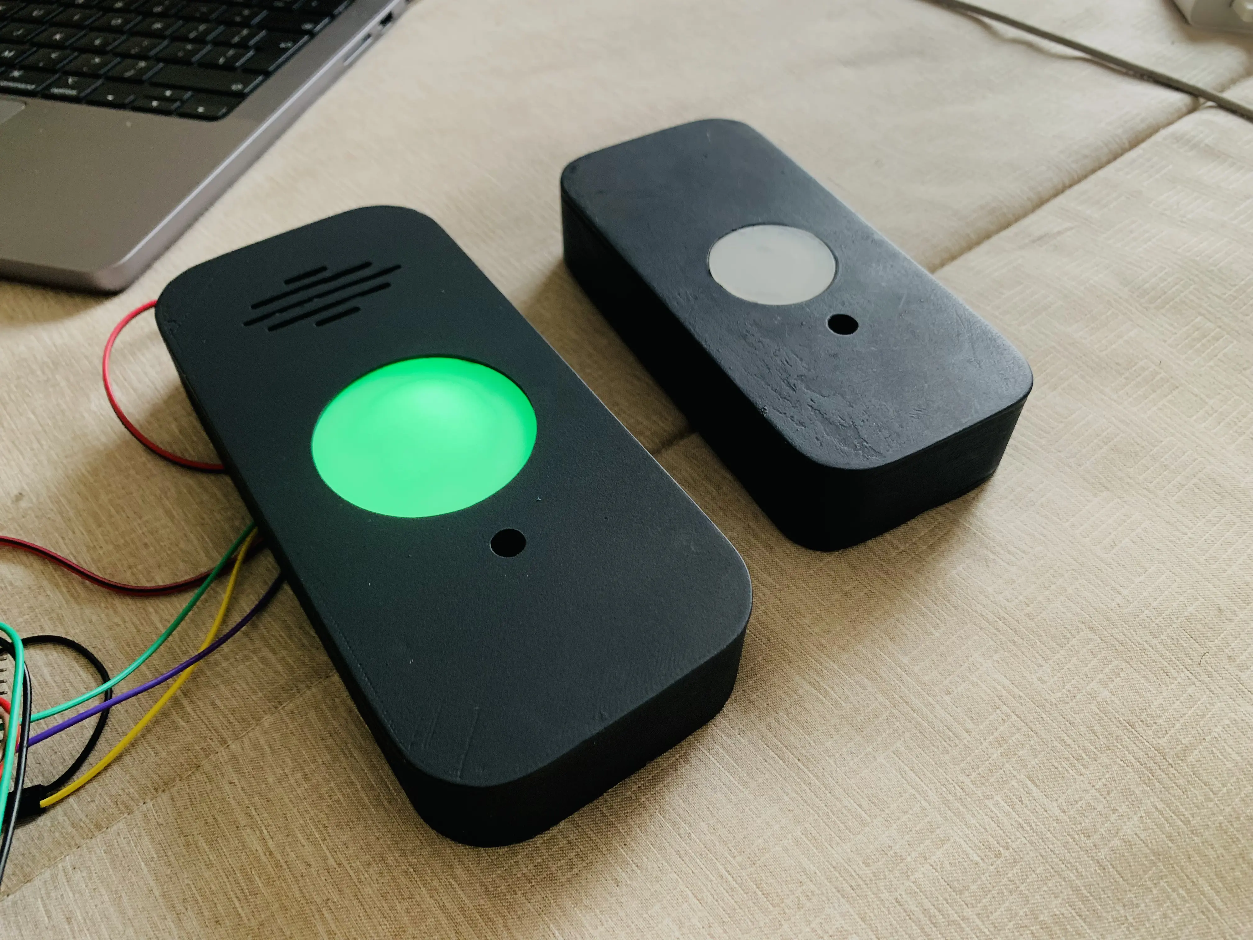 Two KeeLess enclosure prototype iterations side by side, one lit green with exposed wiring