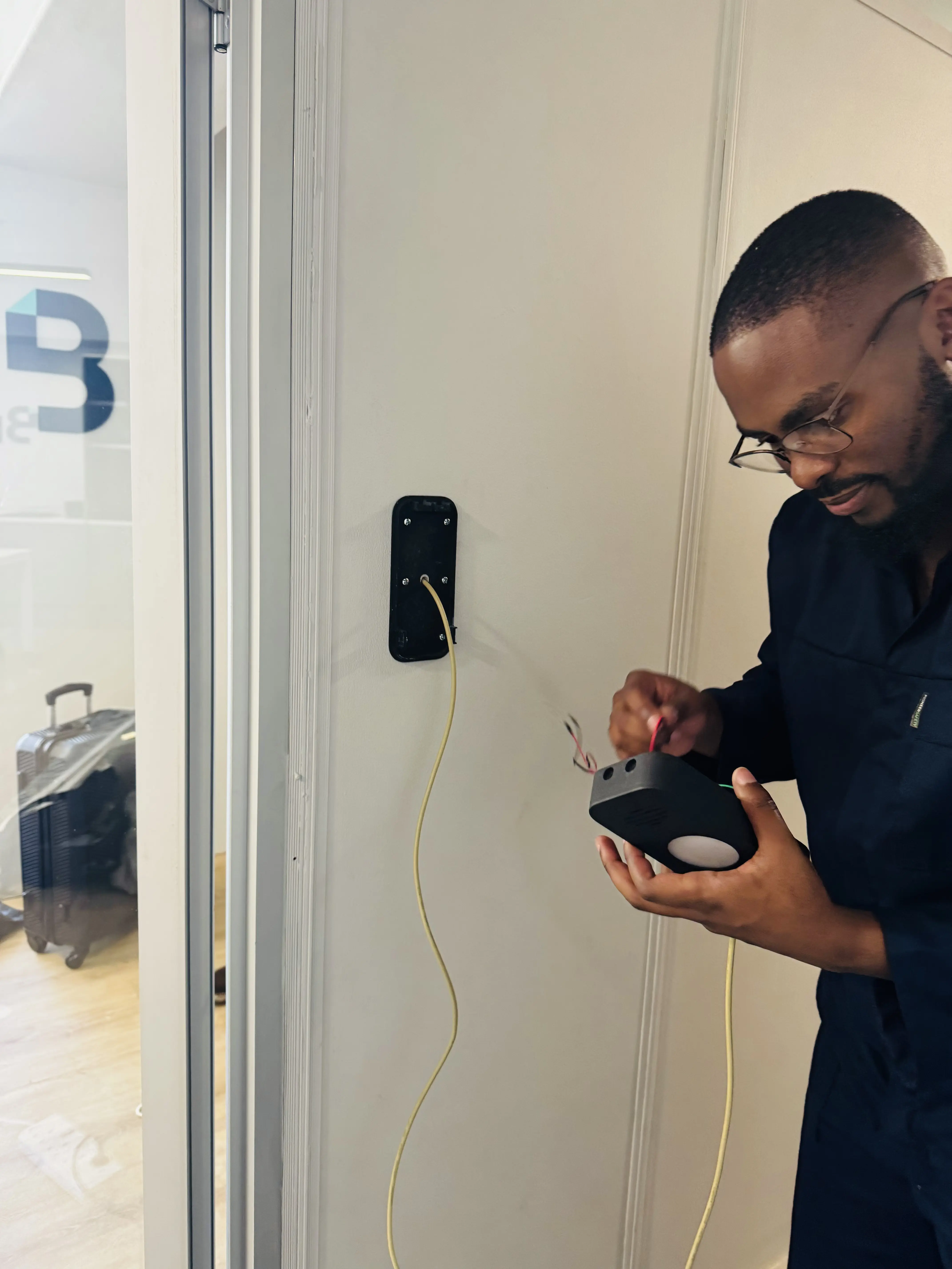 Engineer wiring up a KeeLess reader during a pilot installation
