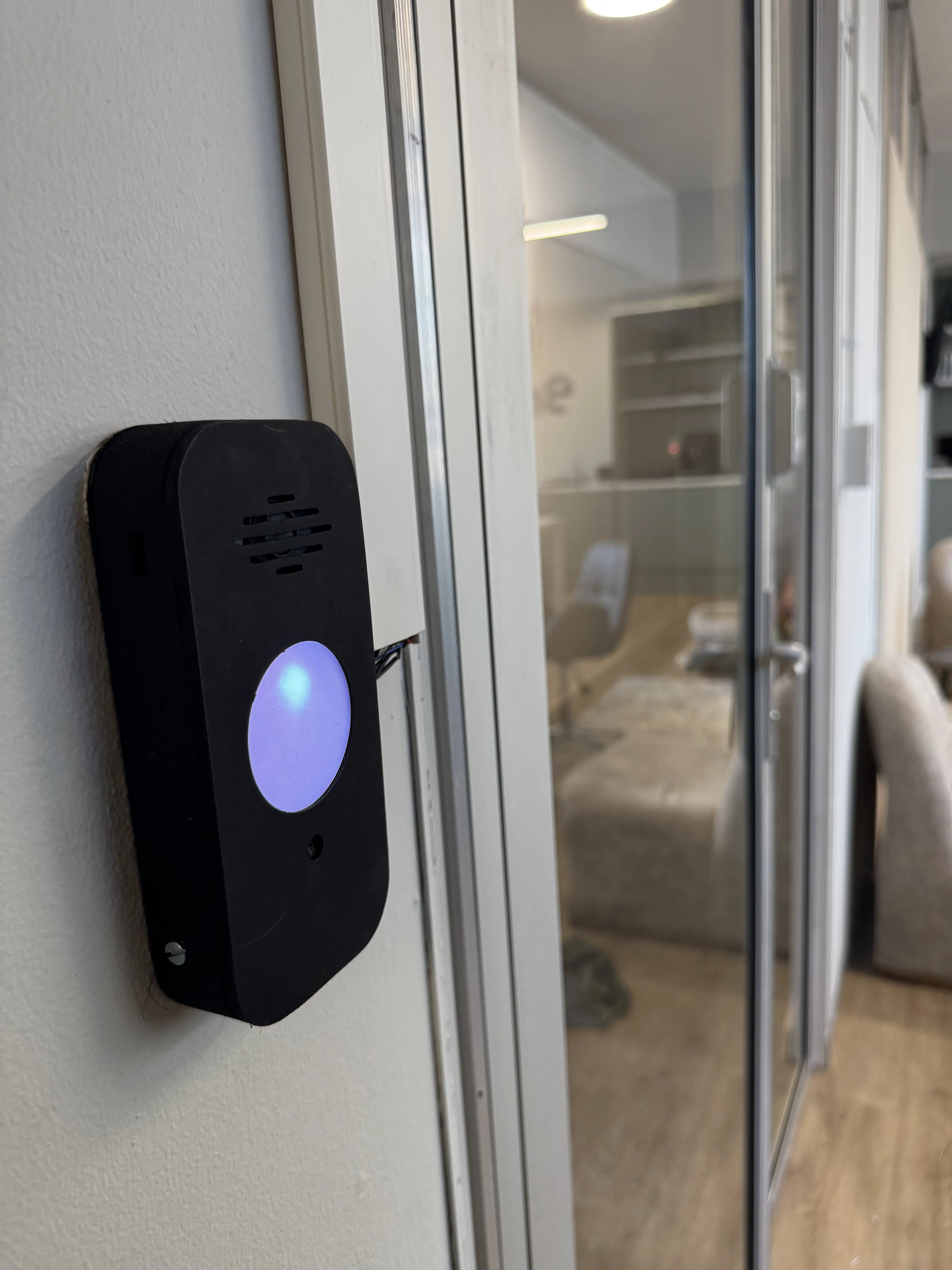 KeeLess reader installed on a glass door frame at a pilot site, glowing blue
